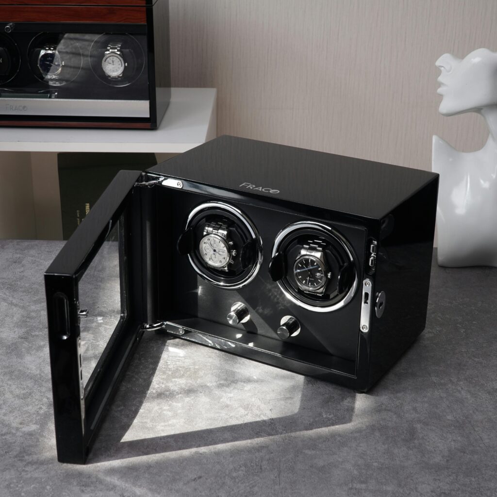 Elegant display of luxury wristwatches in a sleek black watch winder box with modern design.