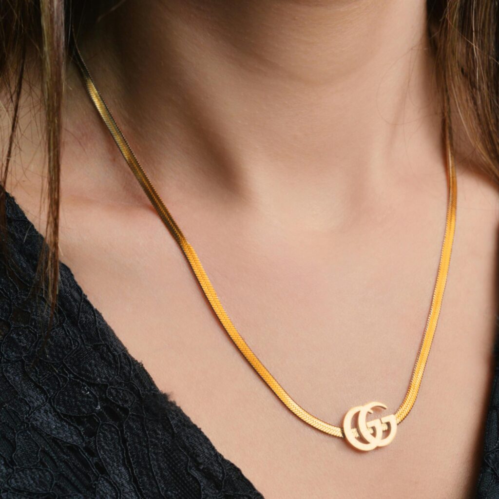 Close-up of a woman wearing a stylish gold necklace, showcasing elegance and luxury.