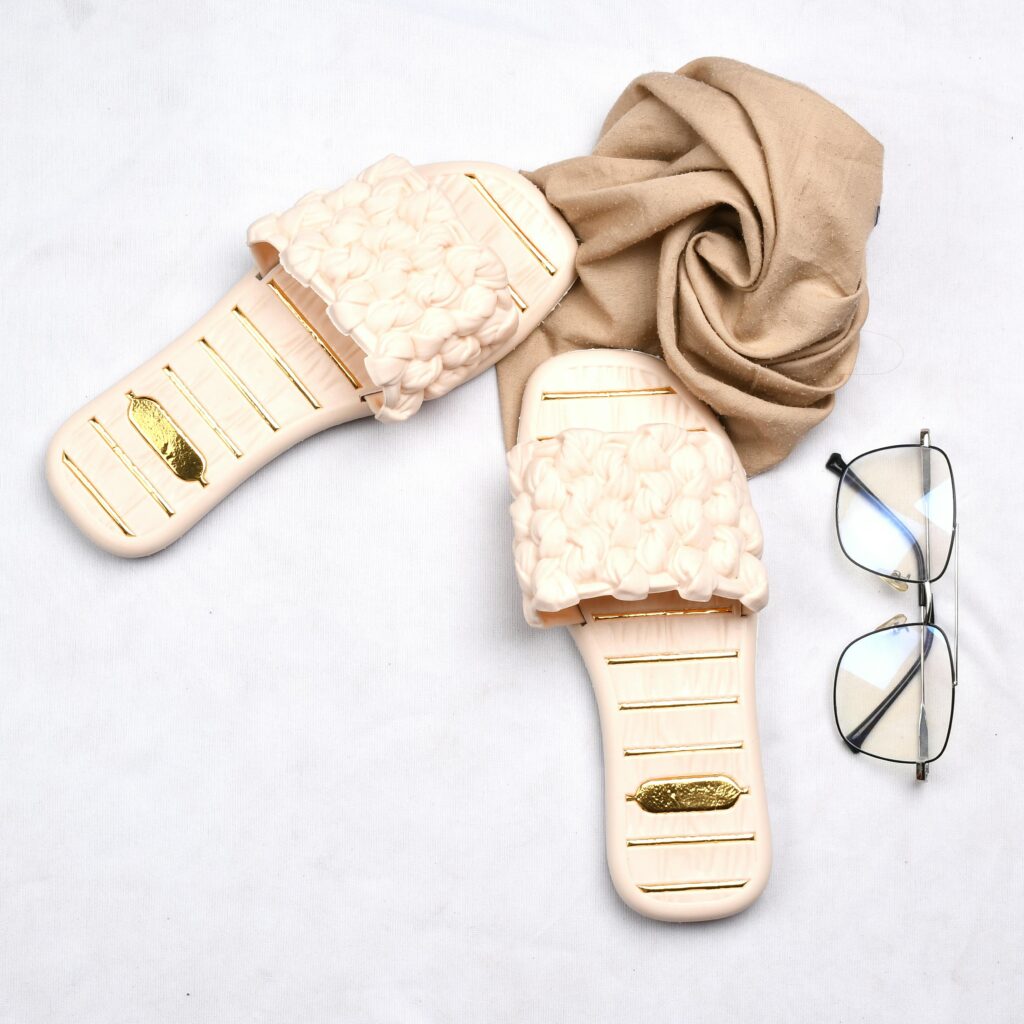 Chic flat lay showcasing stylish cream slippers, eyeglasses, and a beige scarf, perfect for fashion enthusiasts.