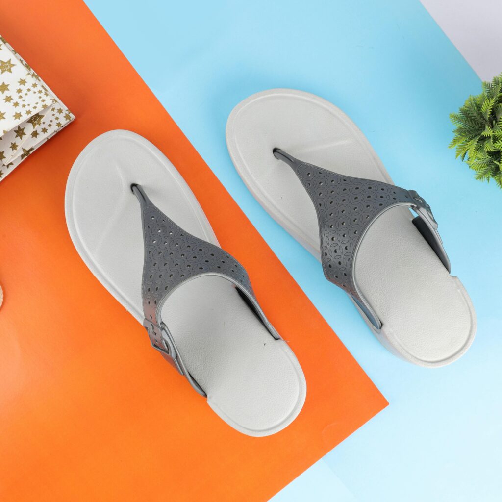 Gray flip-flops displayed on a vibrant orange and blue background, showcasing modern design and style.