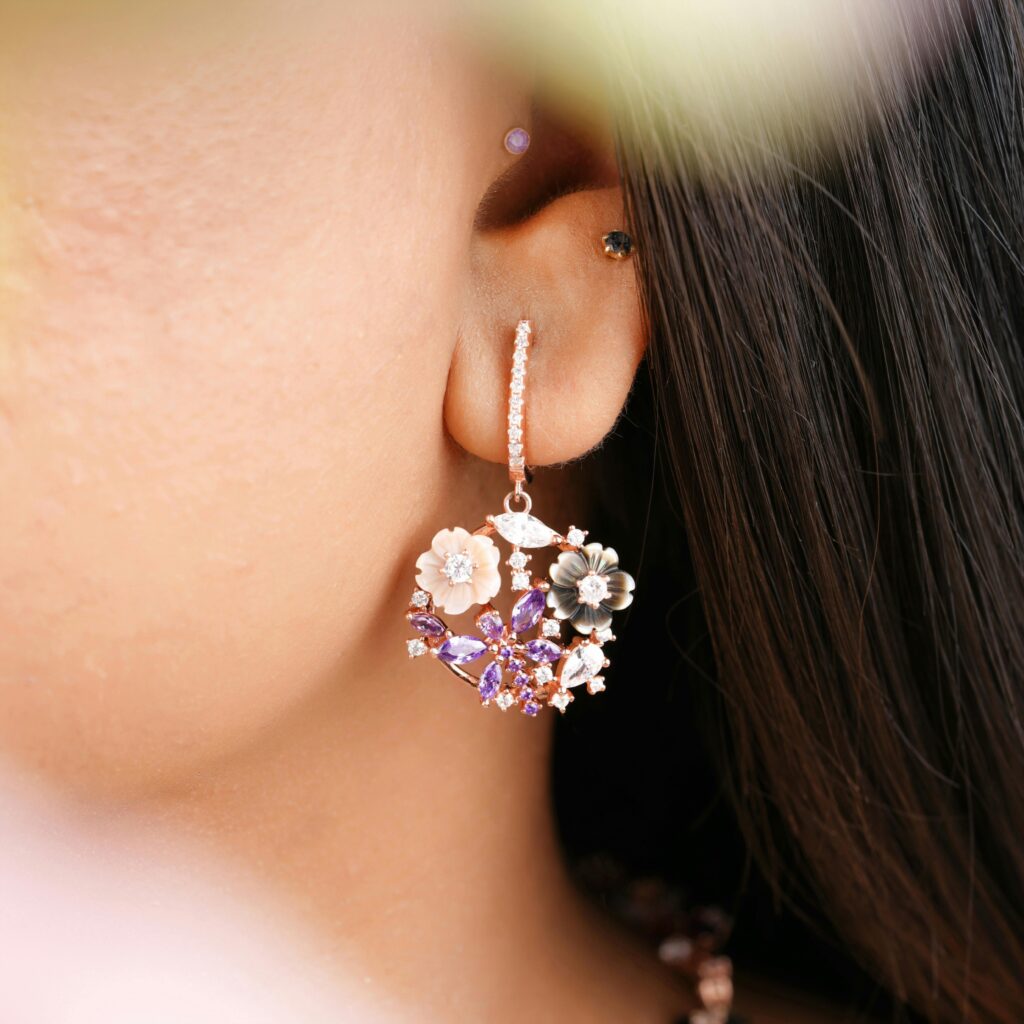 Close-up of a floral diamond earring on a woman's ear, showcasing elegant design.
